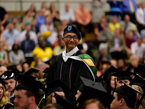 Student standing to be recognized during commencement ceremony.