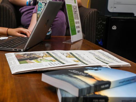 文学杂志和报纸在写作中心的桌子上的照片.